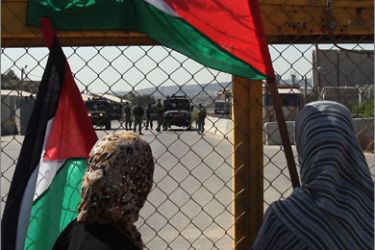 Palestinians stand at the gate of the Israeli controlled Ofer jail during a protest calling for the release of prisoners on August 24, 2009 in the West Bank village of Betunia, near Ramallah.