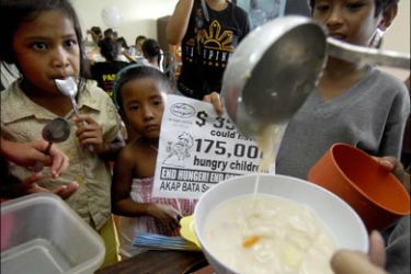 afp : Families stage a protest during a feeding program in a poor area in Manila on August 15, 2009, assailing the alleged lavish spending of Philippine President Gloria Arroyo during