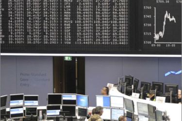 Traders are pictured at their desks in front of the DAX board at the Frankfurt stock exchange September 23, 2009.