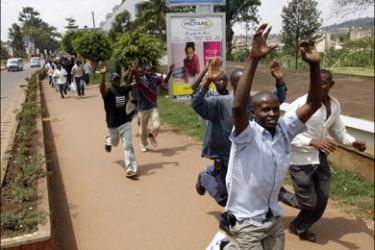 r : Ugandan civilians run with their hands raised along a street in the Wandegeya area of the capital Kampala September 12, 2009. Security forces in Uganda clashed with