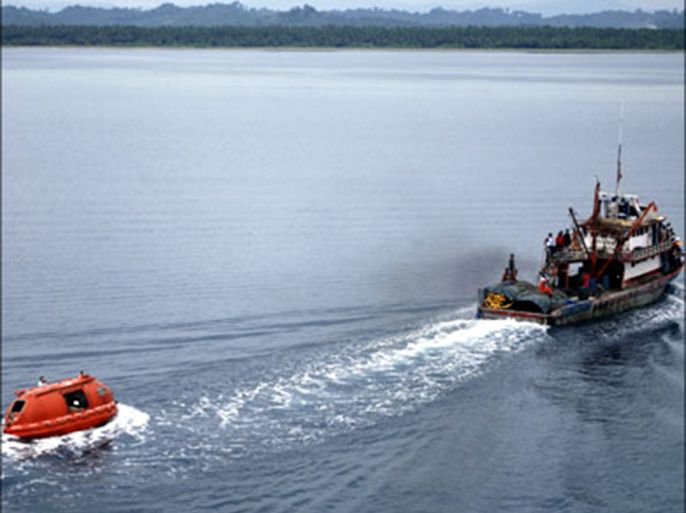 r : A fishing boat with Coast Guard personnel onboard (R) tows to the shore a life boat with four Koreans and 15 Filipino crewmen of the ill-fated Panamanian-registered cargo ship