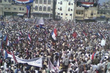 Anti-government demonstrators shout slogans and hold up flags of former South Yemen during a rally in the southern Yemeni city of Dhalea