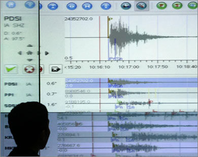 جيولوجي يتابع موجة الزلزال على شاشة (رويترز)