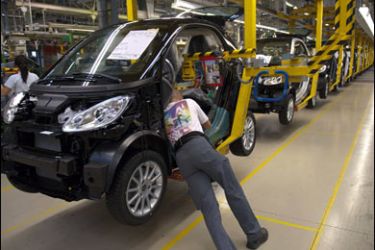 REUTERS/Workers build cars on the assembly line at the Smart car factory in Hambach, eastern France, October 8, 2009.