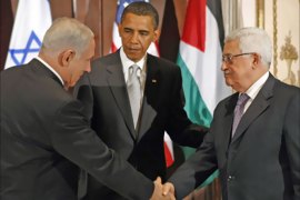 U.S. President Barack Obama (C) watches as Israeli Prime Minister Benjamin Netanyahu (L) and Palestinian President Mahmoud Abbas shake hands during a trilateral meeting