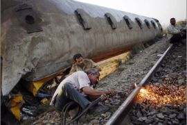 Men work in front of the wreckage of a train at al-Ayyat in Girzah district, south of Cairo October 25, 2009. Two Egyptian passenger trains collided on Saturday near the south of Cairo, killing at least 15 people and leaving passengers trapped