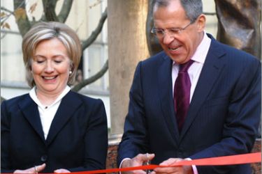 US Secretary of State Hillary Clinton (L) and Russian Foreign Minister Sergei Lavrov (R) cut a red ribbon during the christening ceremony of a monument to