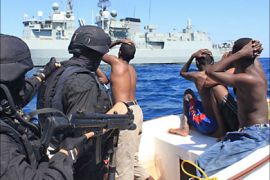Pirates look at the Alvares Cabral vessel after surrendering to Portuguese Marines on November 19, 2009 off the coast of Somalia. The Portuguese navy thwarted an attack