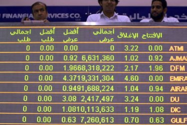 Traders stand above a display screen as they follow the market's movement at the Dubai Financial Market in the Gulf emirate on November 30, 2009. Dubai's stock market plunged 5.94 percent at opening of trading after a long holiday following an announcement by Dubai that it intends to seek a freeze on debt repayments.