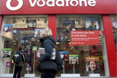 A pedestrian passes a Vodafone store on Oxford Street in central London, November 10, 2009. Vodafone, the world's largest mobile phone operator by revenue, has doubled its cost cutting target to 2 billion pounds