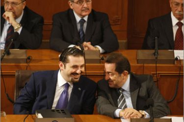 Lebanese Prime Minister Saad Hariri (L) speaks with Labour Minister Boutros Harb (R) at the start of debates on the new government ahead of a vote of confidence at the parliament in Beirut