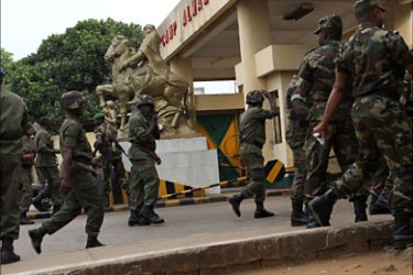 Guinea soldiers walk into camp Almamy Samory Toure in the capital Conakry, December 10, 2009, where Deputy junta leader and Vice-President Sekouba Konate was expected