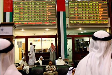 REUTERS/ Investors look at stock exchange information at the Dubai Financial Market December 6, 2009. Dubai's index gave up gains to return to the red as investors book immediate gains