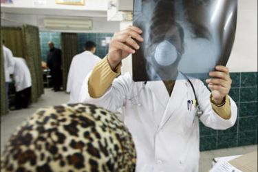 afp : A Palestinian doctor wearing a protective mask against swine flu or influenza A(H1N1) checks an X-ray scan at Al-Shifa hospital in Gaza City on December 8, 2009. Hospital