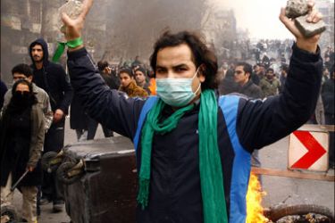 afp : An Iranian opposition supporter gestures during clashes with security forces in Tehran on December 27, 2009. At least five protesters were killed in clashes with security
