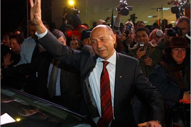 REUTERS / Romania's President Traian Basescu waves to his supporters as he leaves his electoral campaign headquarters in Bucharest December 7, 2009. Basescu, an outspoken anti-corruption campaigner, narrowly won re-election, defeating a leftist challenger for the job of leading