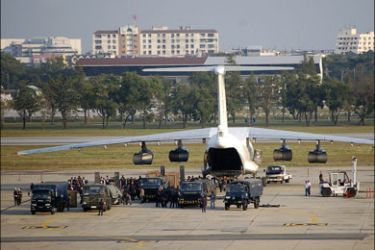 r : Thai security personnel surround a cargo plane that made an emergency landing at Don Muang airport in Bangkok December 12, 2009. Thai security forces seized more than