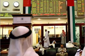REUTERS/ Investors look at stock exchange information at the Dubai Financial Market December 6, 2009. Dubai's index gave up gains to return to the red as investors book immediate gains