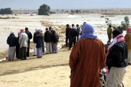 Egyptian men gather around a flooded area on the outskirts of the port town of El-Arish, 45 kilometres (30 miles) from the Gaza border, as heavy rains and floods pounded Egypt's Sinai peninsula, while five ports were closed due to the bad weather on January 18, 2010.