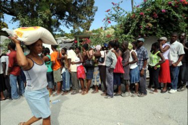 afp : TOPSHOTSHaitians queue at a food distribution point in Port-au-Prince on January 30, 2010. Quake-hit Haiti will need at least a decade of painstaking reconstruction, aid
