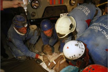 Russian rescuers assist an earthquake survivor in Port-au-Prince January 17, 2010. U.S. troops will help U.N. peacekeepers keep order on Haiti's increasingly lawless streets, the country's president said on Sunday as aid workers struggled to get food and medical assistance to desperate earthquake survivors. Picture taken January 17, 2010
