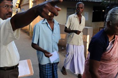 f_An election official (L) guides Sri Lankan ethnic Tamils to their respective booths at a polling station in Vavuniya, some 290 kms north of capital Colombo, on January 26, 2010