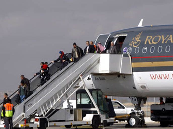 r : Iraqi passengers exit a Royal Jordanian Airline plane at Queen Alia International airport in Amman January 5, 2009. With the support of the Jordanian government, the Royal
