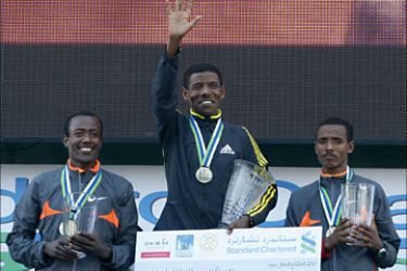 r_Third-placed Ethiopia's Wendimu Tsige Eshetu, winner Ethiopia's Haile Gebrselassie and second-placed Kenya's Dechase Beyene Chala hold their trophies after finishing the