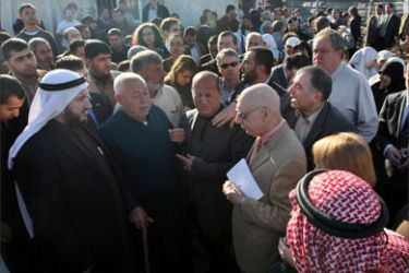 Gerald Kaufman, the head of a European Parliament delegation (C-R), holds a note book and a pen as he meets with residents of Jabalia's Ezbet Abed Rabbo district, an area heavily hit during Israeli's war on Gaza last winter, in the northern Gaza Strip on January 16, 2010.