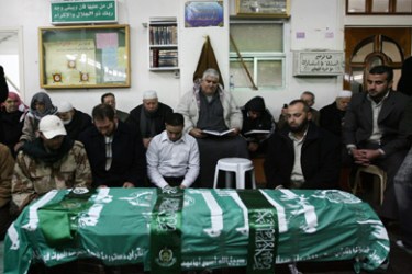 Mourners pray over the Hamas flag-draped coffin of Mahmud al-Mabhuh, one of the founders of the Islamist Hamas movement's military wing, during his funeral at the Yarmuk refugee camp on the southern outskirts of the Syrian capital Damascus on January 29, 2010