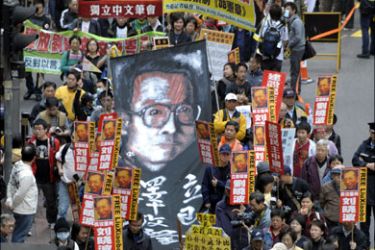 afp : ADDING DETAILPro-democracy demonstators carry a portrait of mainland dissident Liu Xiaobo as they down a street in Hong Kong on January 1, 2010 calling for