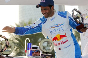 F-Qatari driver Nasser al-Attiyah celebrates on the podium after winning the Qatar International Rally in Doha on January 23, 2010.
