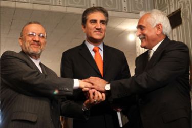 Iranian Foreign Minister Manouchehr Mottaki, Pakistani Foreign Minister Shah Mahmood Qureishi and Afghan Foreign Minister Rangin Dadfar Spanta shake hands during a joint meeting in Islamabad on January 15, 2010