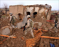 جنود أميركيون يتفقدون ركام منزل دمر في القصف على بلدة مرجه (رويترز)