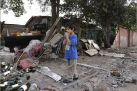 A boy stands amid the rubble of his home after a major earthquake in Santiago February 27, 2010. A huge magnitude-8.8 earthquake struck Chile early on Saturday, knocking down homes and hospitals, and triggering a tsunami that rolled