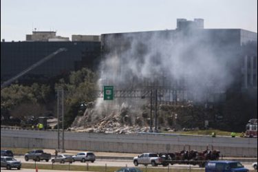 r/Traffic moves by the site where a small aircraft crashed into a building next to an FBI office in the Texas state capital of Austin February 18, 2010.
