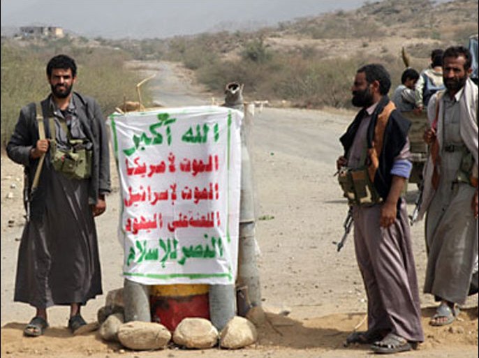 f_Yemeni Shiite Huthi rebels stand at a checkpoint in Saada, north of Sanaa, on February 16, 2010 as others re-open a road following a truce between the rebels and government