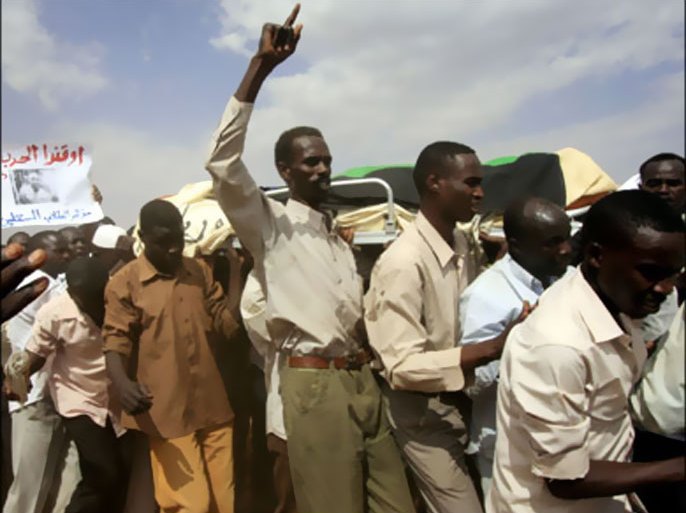 r : Relatives and students shout slogans as they carry the body of Darfuri student Mohamed Musa in Omdurman locality in Khartoum February 15, 2010. Armed riot police