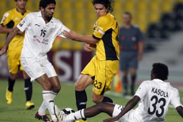Al-Sadd's Talal al-Bloshi (L) and Mohammed Kasola (R) fight for the ball with Qatar club player Sebastian Soria (C) during their Qatar Stars League football match in Doha on February 9, 2010. The match ended in a 1-1 draw.