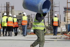 A construction worker carries a barrel as he works on a new building at Queen Alia Airport, 35 km (22 miles) south of Amman,