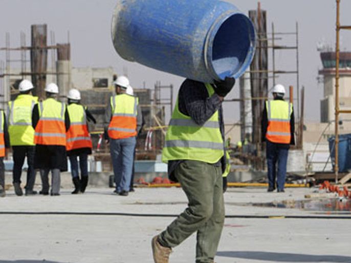 A construction worker carries a barrel as he works on a new building at Queen Alia Airport, 35 km (22 miles) south of Amman,