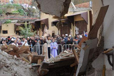 Residents of the Tizimi neighborhood gather outside the collapsed historic mosque in Meknes' old quarter, central Morocco, on February 20, 2010 after the February 19 collapse of the minaret killed at least 41 people and injured another 76 others. Rescuers suspended on February 20 searching the rubble for other possible victims after the minaret of the Bab Berdieyinne mosque crashed on worshippers gathered for Friday prayers