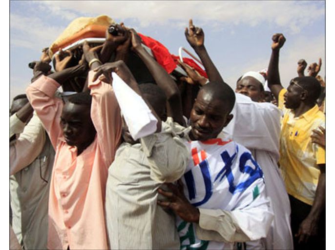 r : Relatives and students carry the body of Darfuri student Mohamed Musa in Omdurman locality in Khartoum February 15, 2010. Armed riot police surrounded hundreds of
