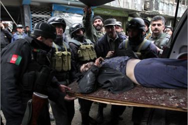 Afghan security forces carry a dead foreigner's body into an ambulance from the site of a gun battle in the Shar-e Naw area in the heart of the capital Kabul on February 26, 2010.