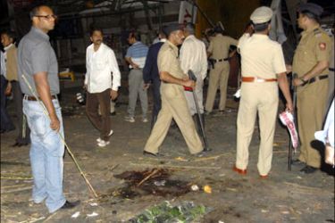 r : Police gather at the site of a bomb blast in Pune February 13, 2010. A bomb ripped through a restaurant popular with foreign tourists in the western Indian city of Pune on