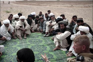 afp : Tribal leaders listens to US Marine Brian Christmas (R), commander of 3rd Battalion, 6th Marines, as they gather in the desert for a meeting in Sistani, Helmand province, on March 28, 2010. The meeting or 'shura' took