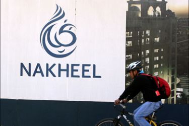 epa : 01966155 A cyclist passes by a poster of Nakheel company on Palm Jumeira Island, Dubai, United Arab Emirates on 15 December 2009. The government of Dubai