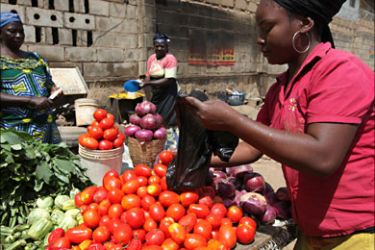 r_A woman sells tomatoes at a roadside grocery stall in Nigeria's central city of Jos March 9, 2010. Nigeria must prosecute those behind a weekend massacre and address underlying issues