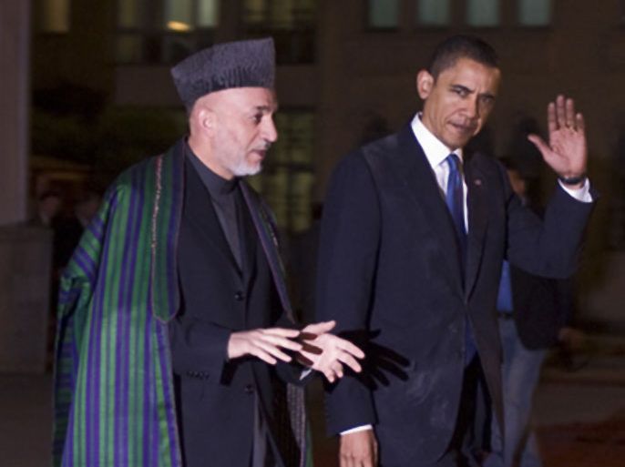US President Barack Obama (R) walks with Afghan President Hamid Karzai during a welcoming ceremony at the Presidential Palace in Kabul on March 28, 2010.