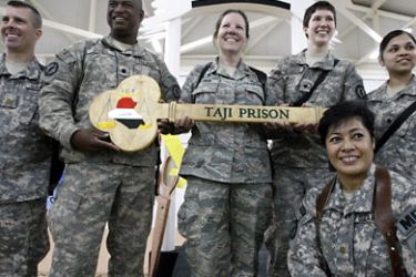US soldiers pose with a wooden key to Taji prison, a 107-million-dollar compound that can hold up to 5,600 prisoners and is located about 25 kilometres (15 miles) north of Baghdad, during a ceremony to transfer control of one of the US' two remaining detention facilites to Iraqi authorities on March 15, 2010. AFP